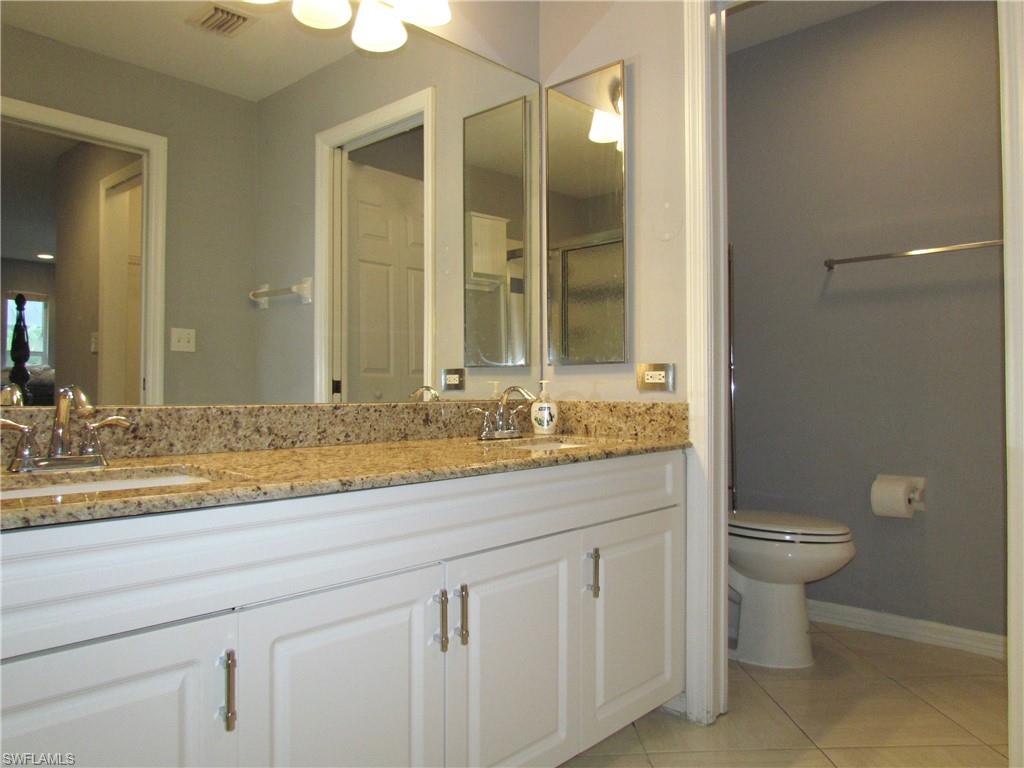 9124 Morris Road Fort Myers, FL 33967 - Photo 20 of 29 a bathroom with a granite countertop sink a toilet and a mirror