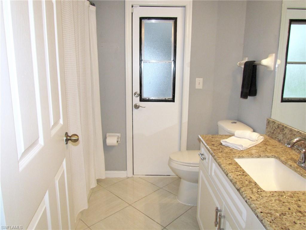 9124 Morris Road Fort Myers, FL 33967 - Photo 23 of 29 a bathroom with a granite countertop sink a mirror and a toilet
