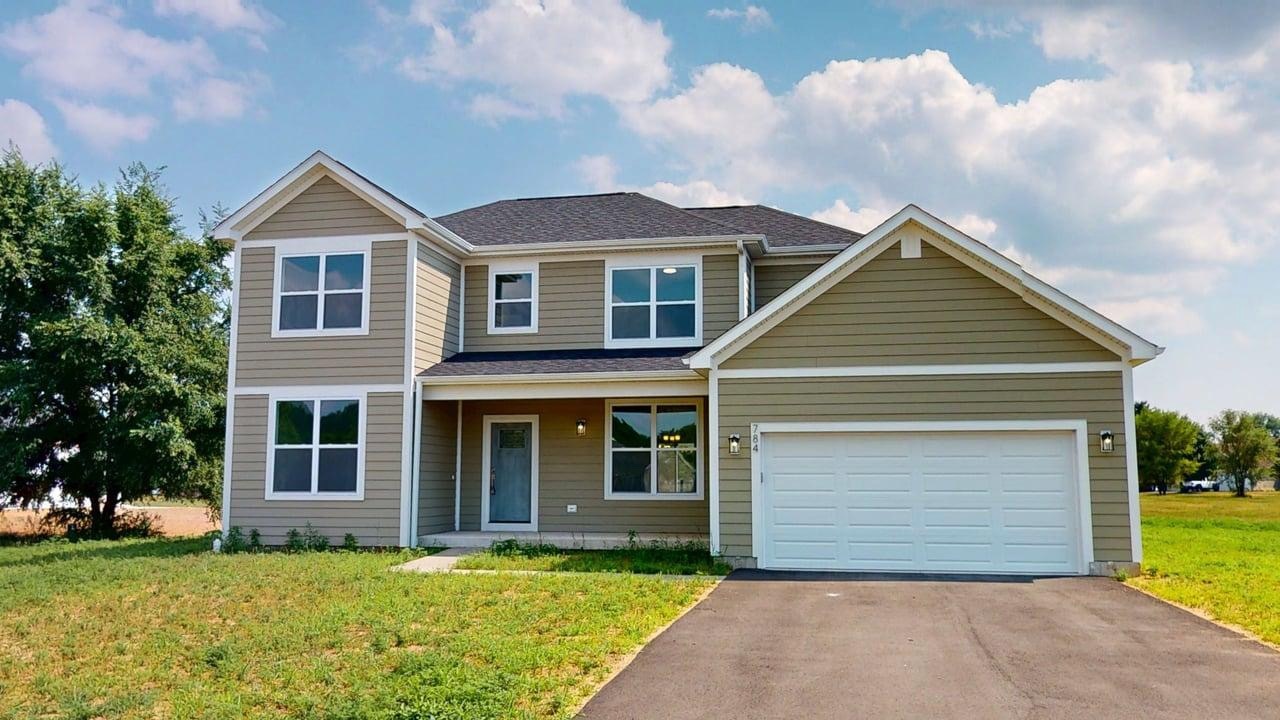 a front view of a house with a garden and yard