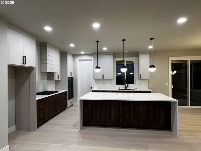 a large kitchen with a large counter top stainless steel appliances and cabinets
