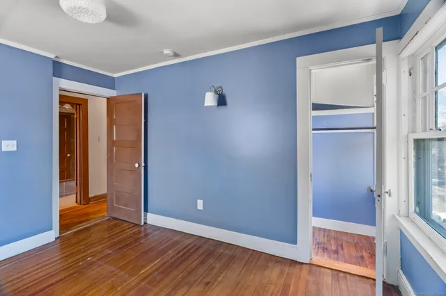 a view of empty room with wooden floor