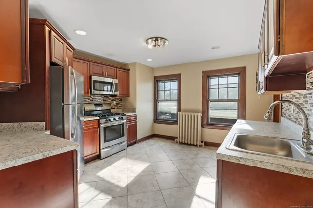 a kitchen with stainless steel appliances granite countertop a sink stove and refrigerator