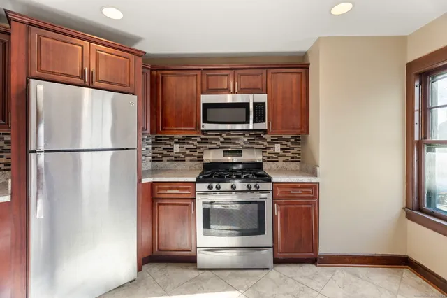 a kitchen with stainless steel appliances granite countertop a refrigerator stove and microwave
