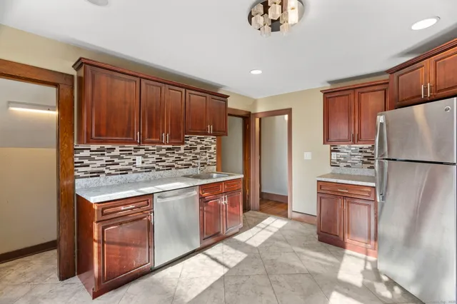 a kitchen with stainless steel appliances granite countertop a refrigerator and a stove top oven