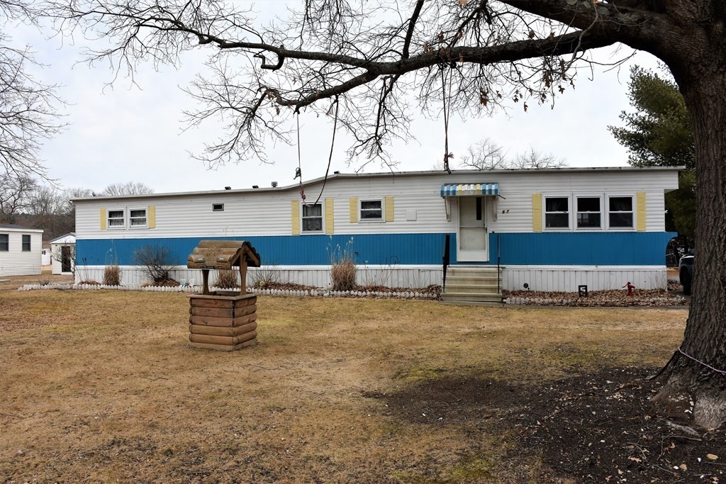 a front view of a house with yard and sitting area