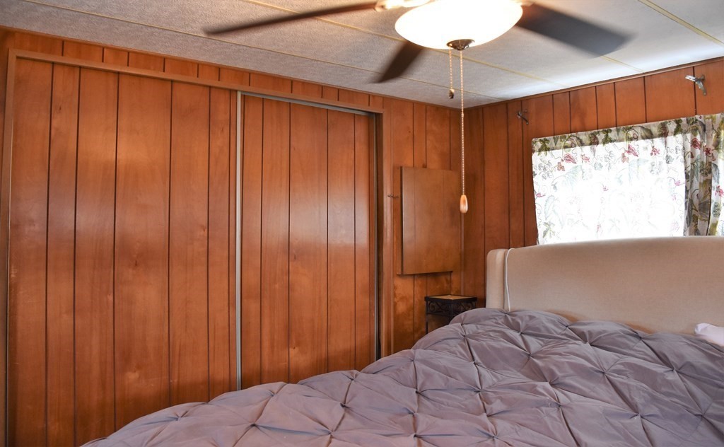 67 Breezy Lane Thompson, CT 06262 - Photo 14 of 17 a bedroom with a bed and a chandelier fan