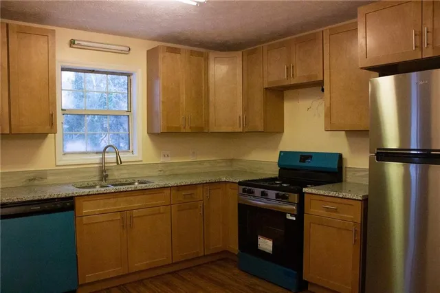 a kitchen with a sink a refrigerator and cabinets