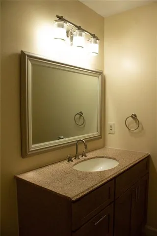a bathroom with a granite countertop sink and a mirror
