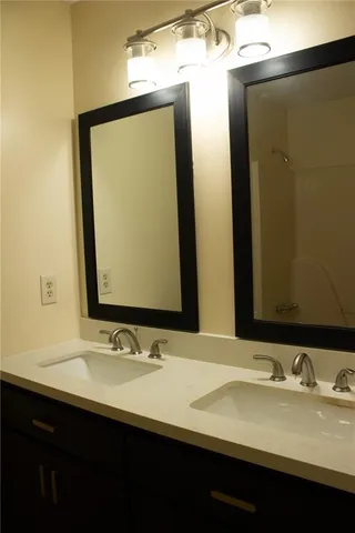 a bathroom with a double vanity sink and a mirror