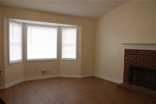 an empty room with wooden floor and a window