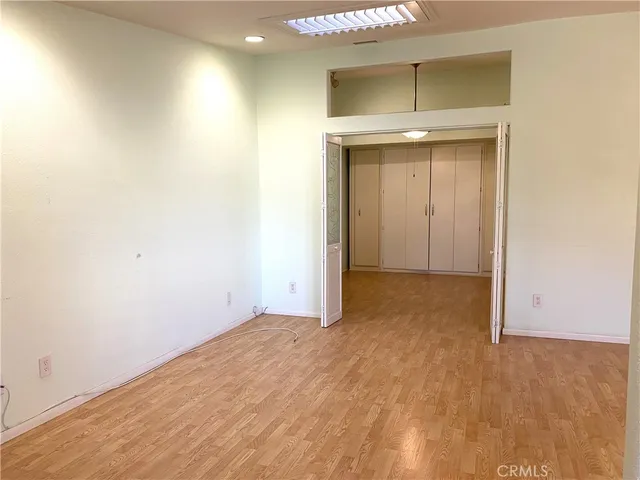 a view of an empty room with wooden floor