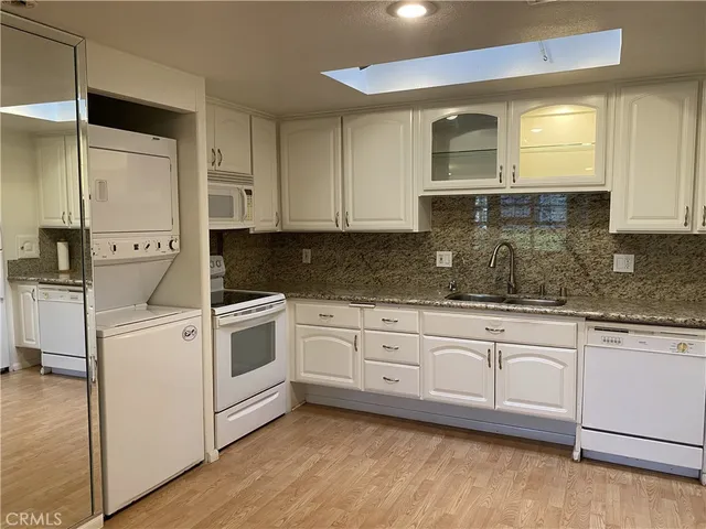 a kitchen with granite countertop white cabinets and white appliances