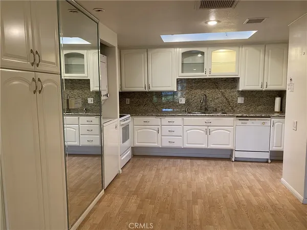 a large kitchen with granite countertop a stove a sink and a refrigerator