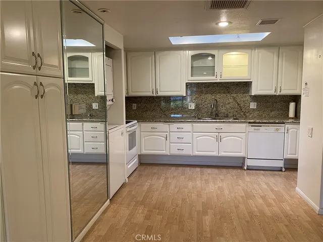 a large kitchen with granite countertop a stove a sink and a refrigerator
