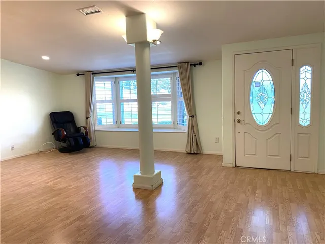 a view of empty room with wooden floor and fan