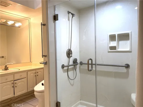 a bathroom with a granite countertop sink toilet and shower