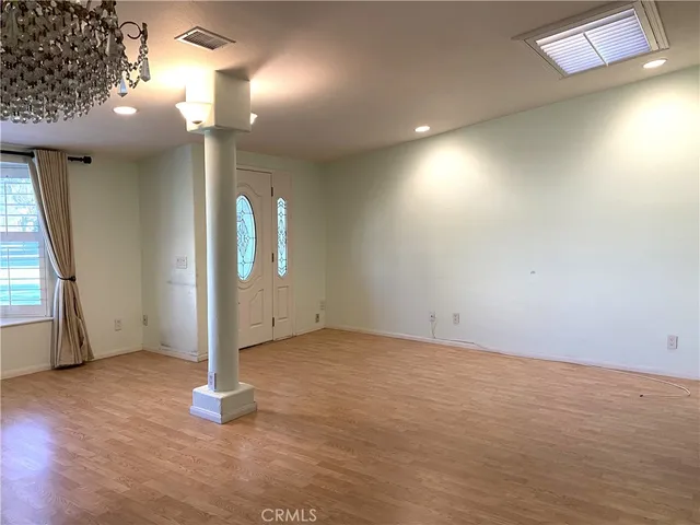 an empty room with wooden floor and a window