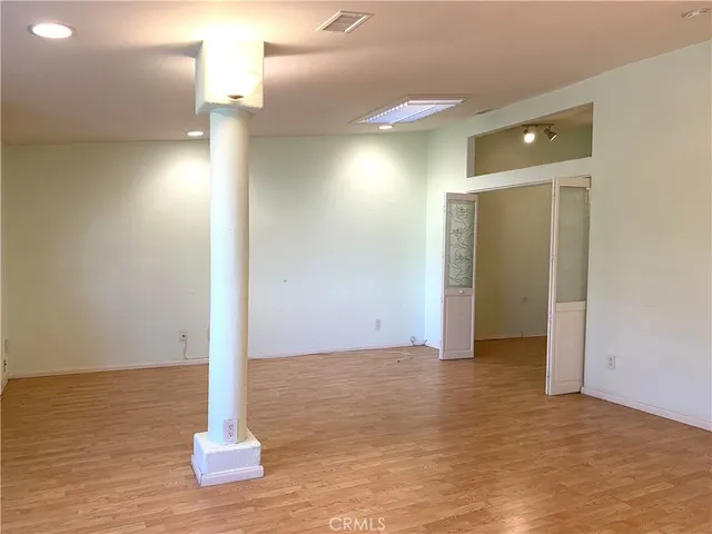a view of empty room with wooden floor