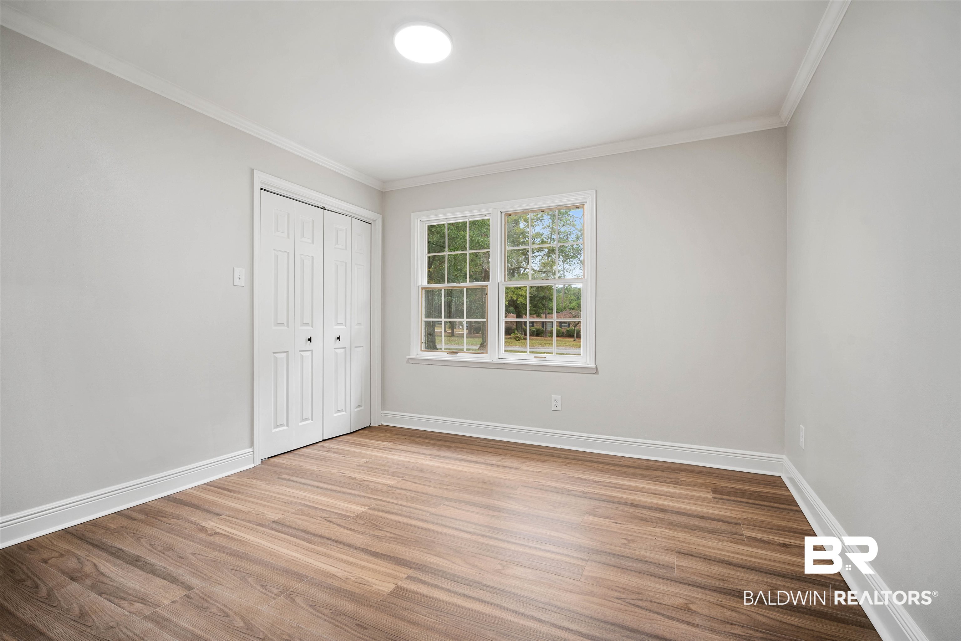 3050 Lacoste Road Mobile, AL 36618 - Photo 19 of 30 Unfurnished bedroom featuring light wood-style flooring, ornamental molding, and a closet