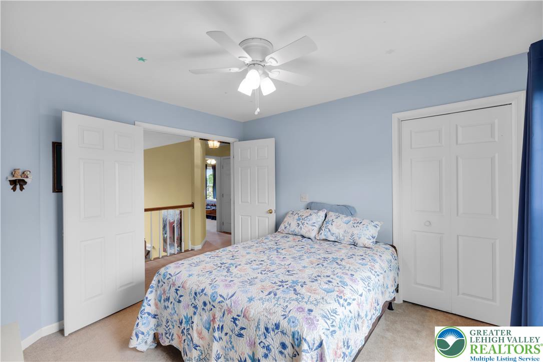 3830 McIntosh Drive Orefield, PA 18069 - Photo 18 of 36 a bedroom with a bed and a chandelier