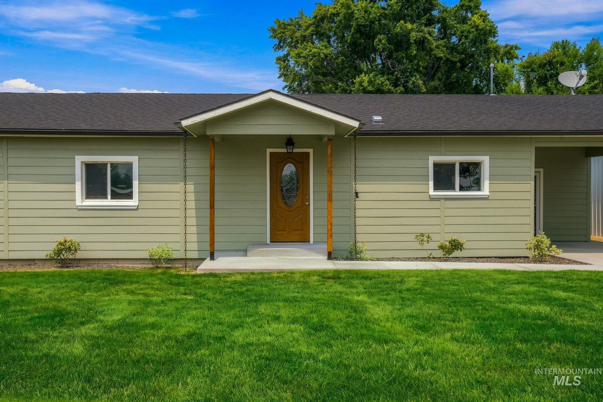 14666 Willis Road Caldwell, ID 83607 - Photo 9 of 50 Ranch-style exterior with sage green horizontal siding, dark shingle roofing, and white window trim
