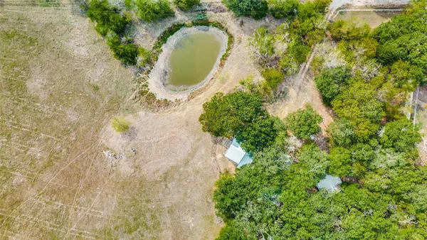 a aerial view of a house with a swimming pool and large trees
