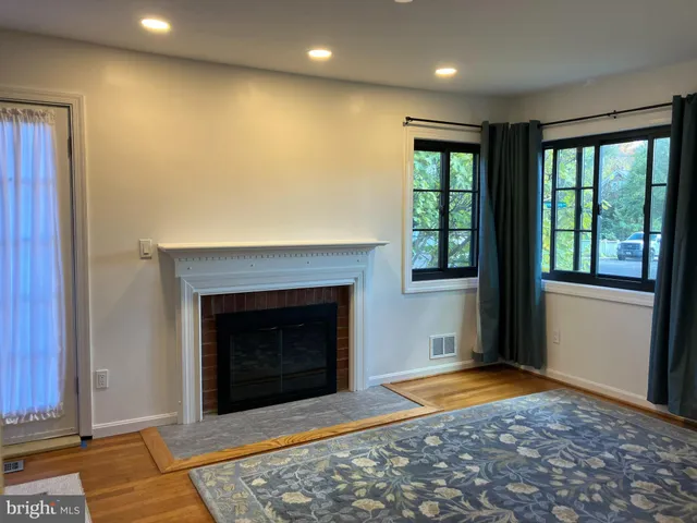a view of an empty room with a fireplace and a window