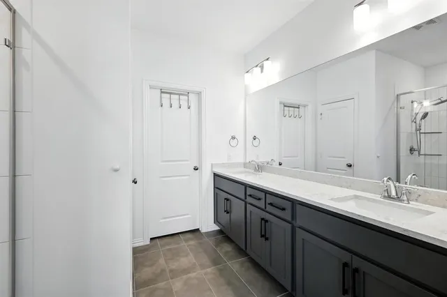 a bathroom with a double vanity sink and a mirror