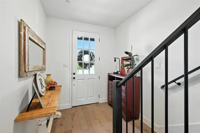 a view of an entryway with wooden floor and livingroom