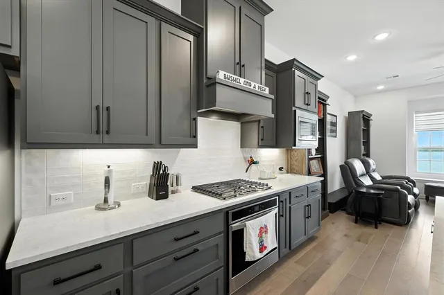 a kitchen with stainless steel appliances a stove a sink dishwasher and cabinets with wooden floor