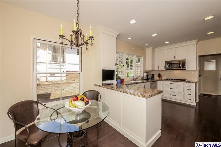 1963 New York Drive Altadena, CA 91001 - Photo 9 of 38 a kitchen with stainless steel appliances kitchen island granite countertop a stove a sink a refrigerator a dining table and chairs with wooden floor