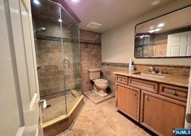a spacious bathroom with sink shower and mirror