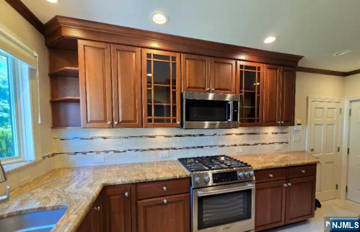 9 Harris Place, Unit 1X Fair Lawn, NJ 07410 - Photo 5 of 18 a kitchen with stainless steel appliances granite countertop a stove a sink and a microwave