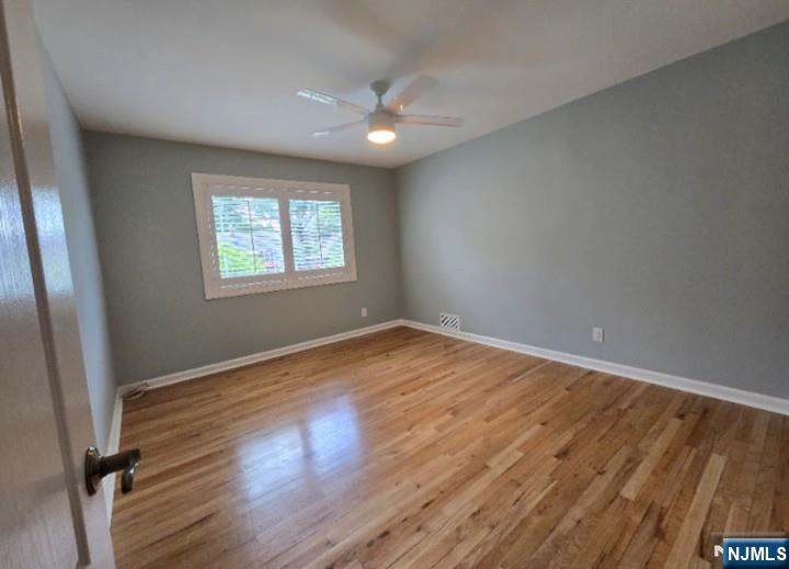 9 Harris Place, Unit 1X Fair Lawn, NJ 07410 - Photo 6 of 18 an empty room with wooden floor and windows