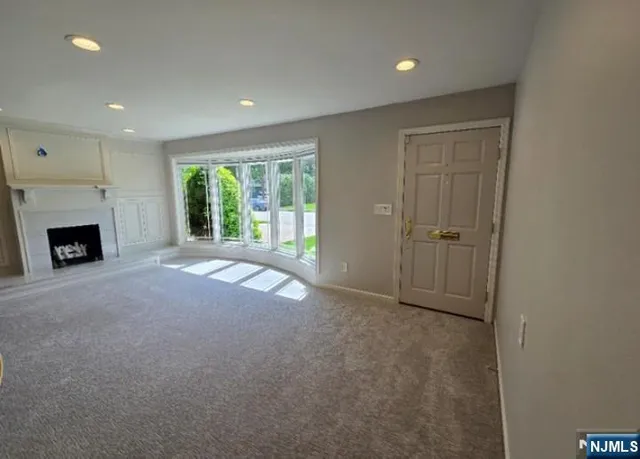a view of an empty room with a fireplace and a window