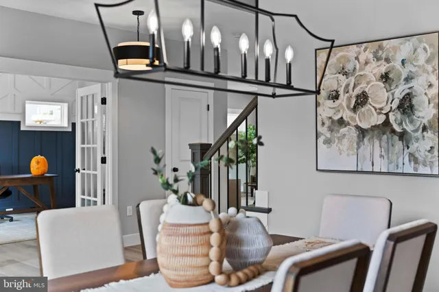 a dining room with wooden floor a chandelier a wooden table and chairs