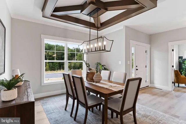 a dining room with furniture a chandelier and wooden floor