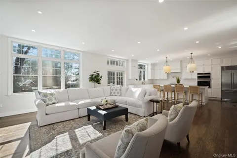 a living room with furniture wooden floor and a large window