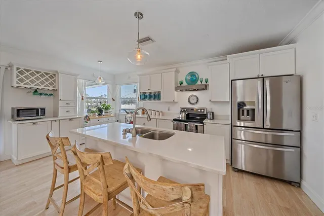 a living room with furniture and a flat screen tv with kitchen view