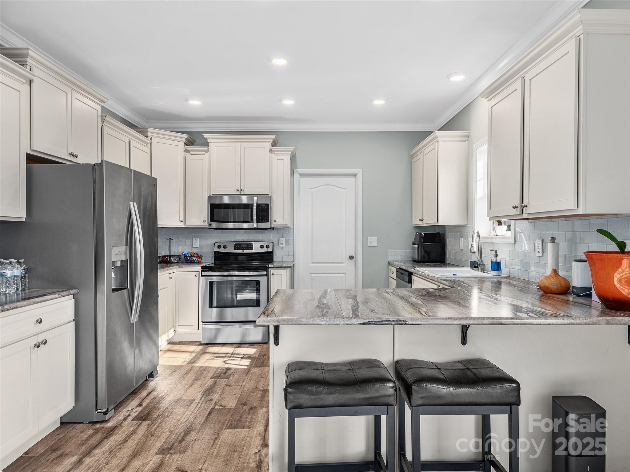 508 Fanning Bridge Road Fletcher, NC 28732 - Photo 8 of 21 a kitchen with stainless steel appliances granite countertop a stove a sink a refrigerator with white cabinets and wooden floor