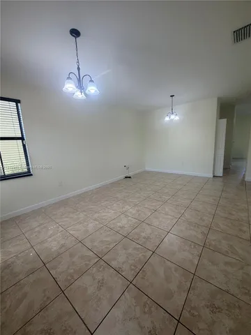 a view of empty room with wooden floor and ceiling fan