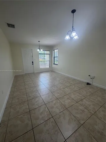 a view of a livingroom with a chandelier fan and windows