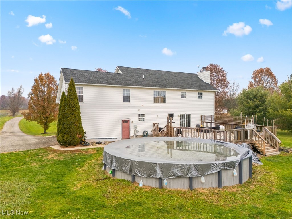 7374 Virginia Road Atwater, OH 44201 - Photo 38 of 49 Back of house with a yard, a deck, a chimney, and a covered pool