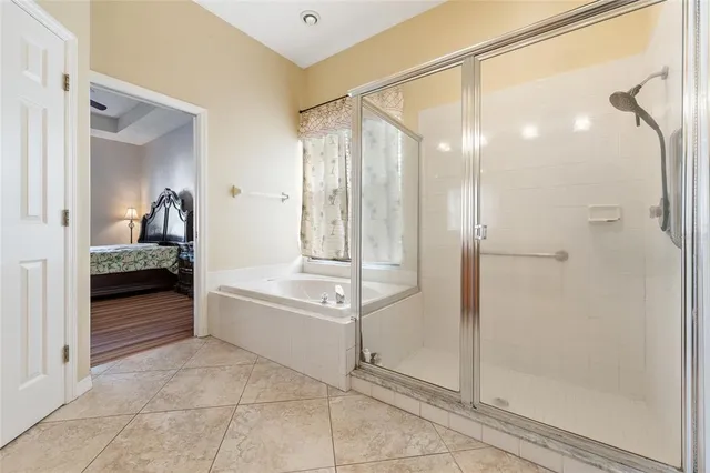 a en suite bathroom with a tub shower and mirror