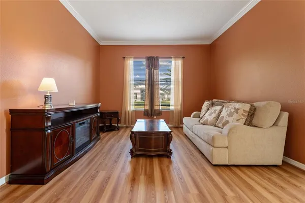 a living room with a couch wooden floor and a window