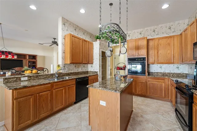 a kitchen with cabinets a counter and chairs