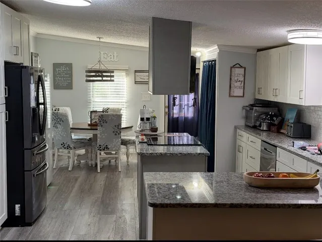 a kitchen with stainless steel appliances granite countertop a stove refrigerator and cabinets
