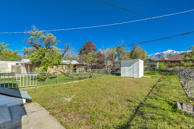 712 9th Street Ogden, UT 84404 - Photo 15 of 15 Expansive green space featuring a storage shed and chain-link fencing