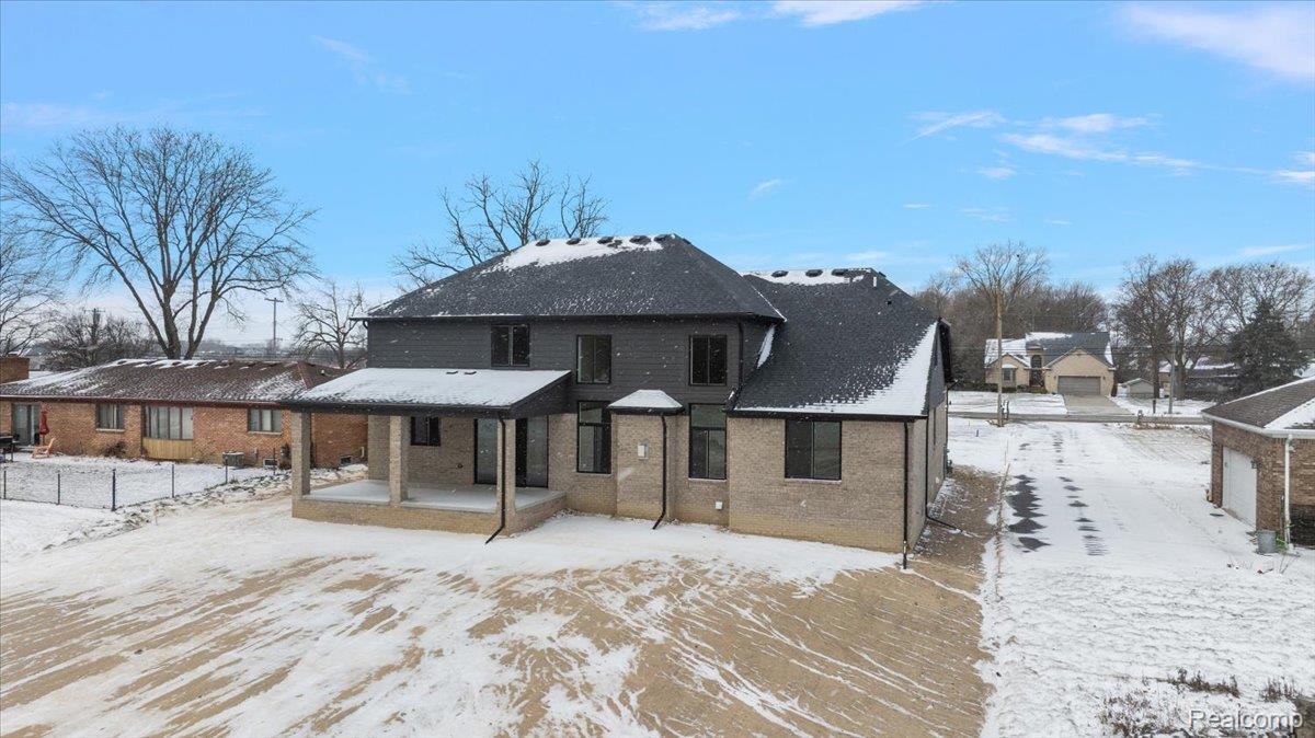 53650 Romeo Plank Road Macomb, MI 48042 - Photo 55 of 64 Snow covered property with brick siding and a patio