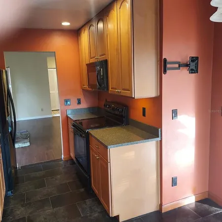 a kitchen with stainless steel appliances granite countertop a refrigerator a stove and a sink